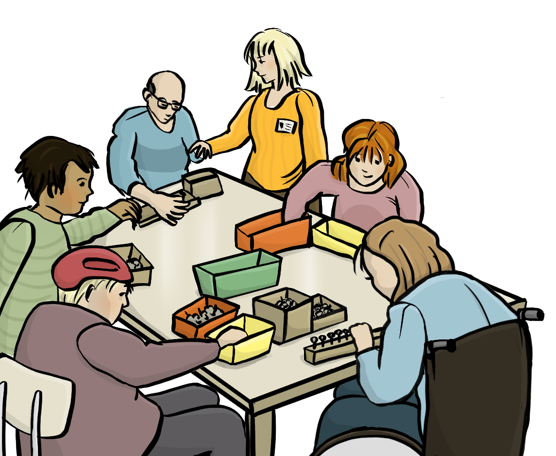 Menschen mit Behinderungen sitzen um einen Tisch herum und legen Dinge in Schachteln. Eine Frau mit einem Namensschild hat einem Mann die Hand auf die Schulter gelegt.