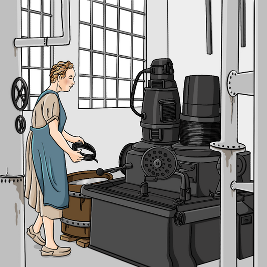 Eine Frau in einem Arbeitskittel steht in einer Fabrikhalle. Sie hält eine Drahtrolle in der Hand.&nbsp;