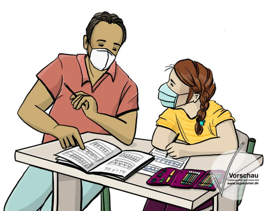 Ein Mädchen sitzt an einem Schultisch. Auf dem Tisch liegt ein Schulheft und ein Etui. Ein Assistent sitzt neben dem Mädchen. Er zeigt auf das Schulheft. Beide tragen einen Mundschutz.