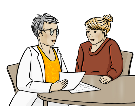 Eine Frau und eine Ärztin sitzen an einem Tisch. Die Ärztin hält Papiere in der Hand und sagt etwas zur Frau.