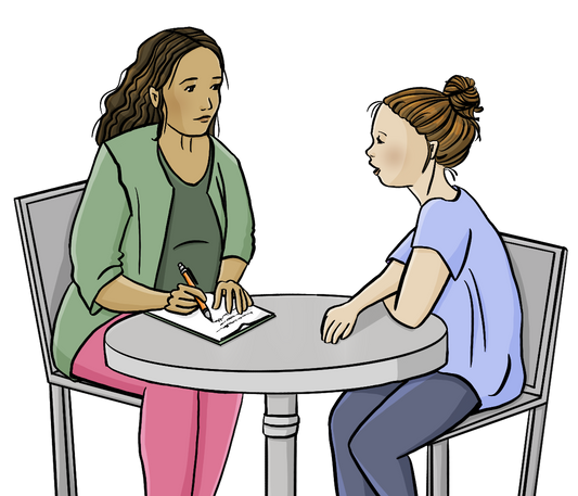 Eine junge Frau und eine Beraterin sitzen an einem Tisch. Die junge Frau redet. Die Beraterin schreibt mit.
