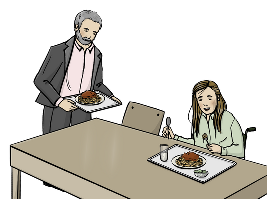 Eine Frau sitzt an einem Tisch. Vor ihr steht ein Tablett mit Essen. Sie führt eine Gabel zum Mund. Ein Mann kommt mit einem Tablett mit Essen zum Tisch.