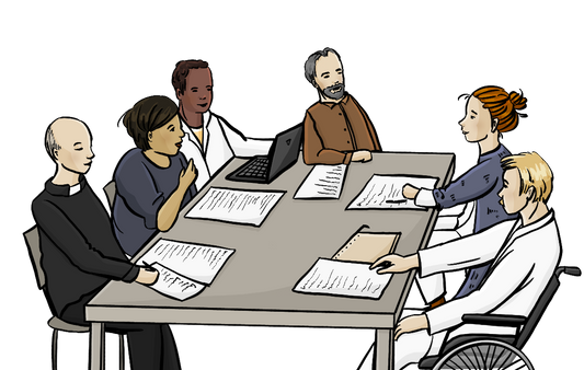 Eine Gruppe Menschen sitzt um einen Tisch. Auf dem Tisch liegen Papiere. Es sind Ärzte dabei und ein Pfarrer.