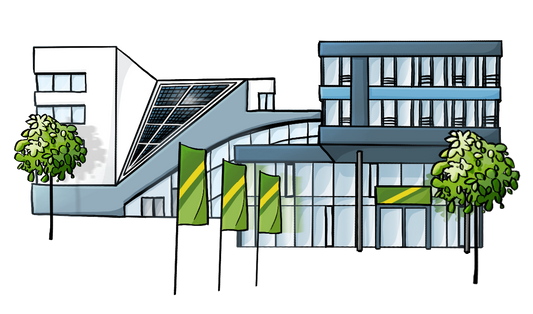Ein modern aussehendes Gebäude mit vielen Glasflächen. Auf dem Dach ist eine Solar-Anlage. Vor dem Gebäude stehen Bäume und grüne Flaggen.
