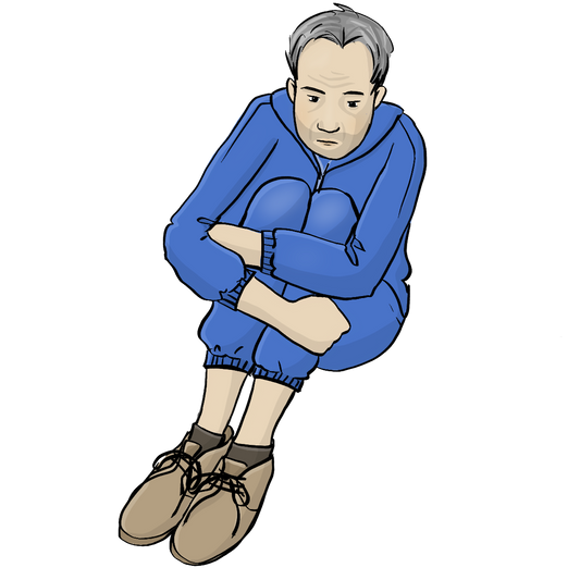 Ein Mann sitzt auf dem Boden und hat die Arme um die Beine geschlungen. Er trägt einen zu kurzen blauen Trainings-Anzug. 