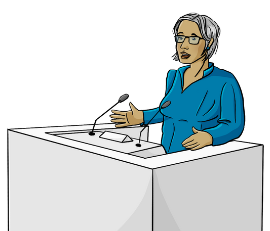 Eine Frau steht an einem Rednerpult.