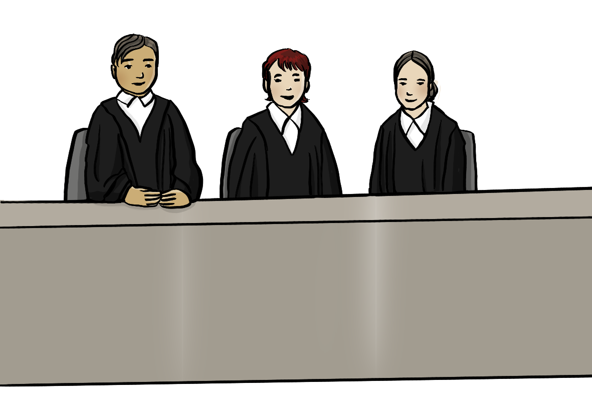 Ein Mann und zwei Frauen in schwarzen Roben sitzen an einem langen Tisch.