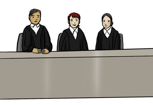 Ein Mann und zwei Frauen in schwarzen Roben sitzen an einem langen Tisch.