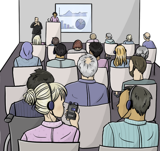 Stuhlreihen mit Menschen von hinten. Einige Menschen tragen Kopfhörer. Vorne hält eine Frau einen Vortrag. In der hinteren Reihe haben sich zwei Personen mit Kopfhörern einander zugewendet. Die Eine Person hält ein Empfängergerät in der Hand.