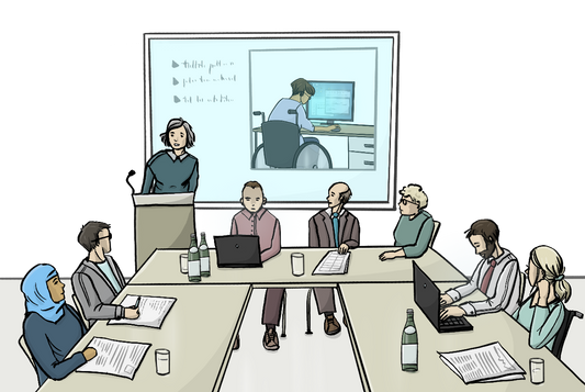 Eine Frau steht an einem Rednerpult, davor sitzen Menschen an Tischen. Auf den Tischen sind Papiere und Laptops. Im Hintergrund ist eine Leinwand mit dem Bild von einer Frau im Rollstuhl. Sie sitzt an einem Computer.